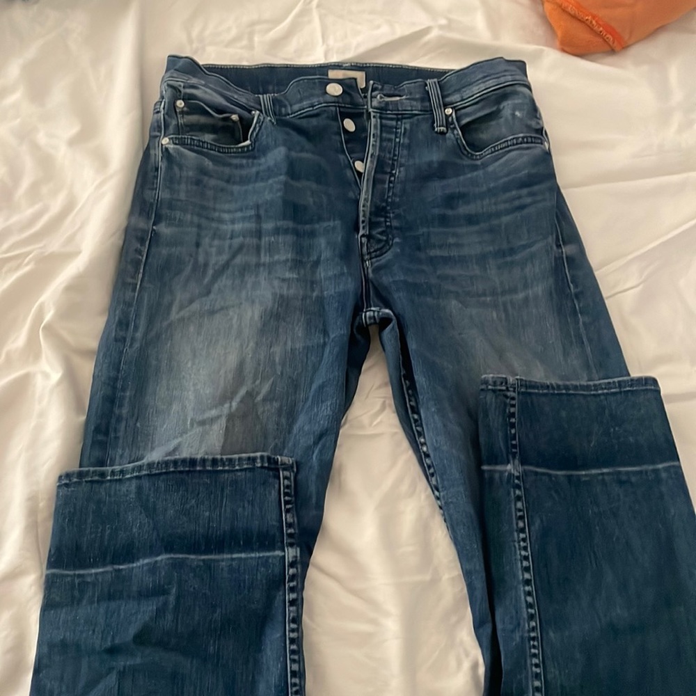 Mother jeans the tomcat button fly markings at the ankle from being washed